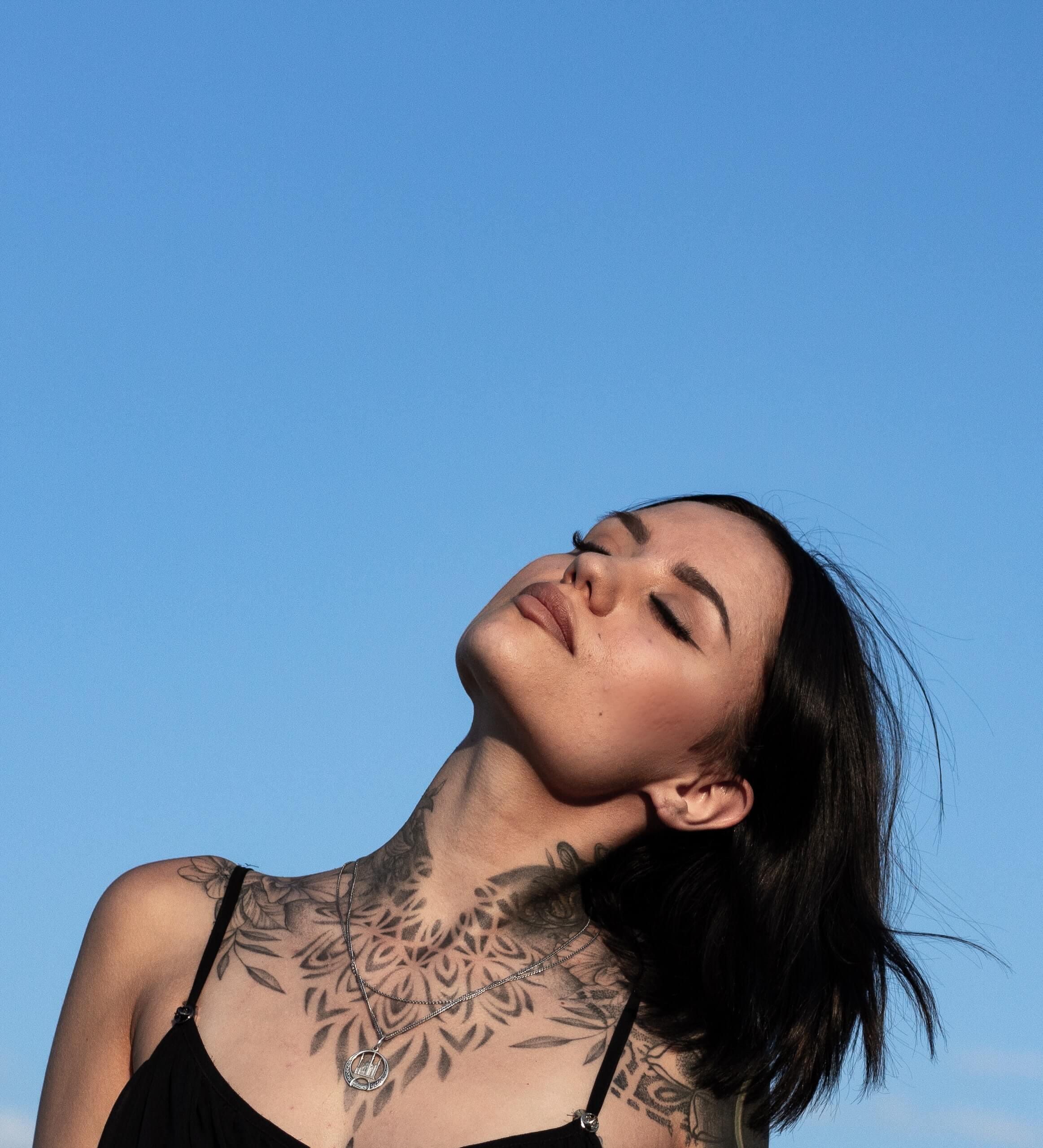 Geometric tattoo design on a woman's neck